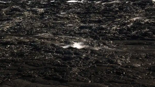 A dark black lava field is steaming